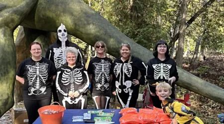 AAACU Team members pose with bags of trash they cleaned up in the community.
